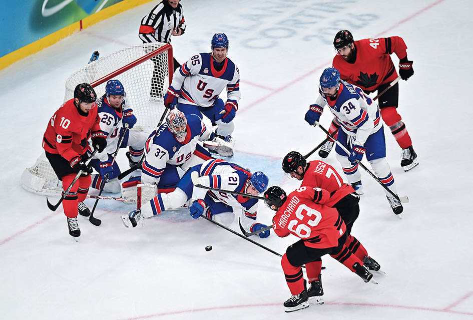 2026年2月22日，加拿大队球员马尔尚（下）在意大利米兰举行的米兰 - 科尔蒂纳冬奥会冰球项目男子金牌赛中射门 希夷摄/本刊