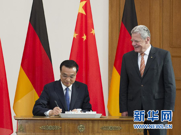 10月10日，國務院總理李克強在柏林會見德國總統高克。這是李克強總理在高克總統的陪同下在貴賓簿上簽字。 新華社記者 王曄 攝 