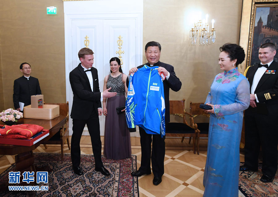 當?shù)貢r間4月5日晚，國家主席習近平和芬蘭總統(tǒng)尼尼斯托在赫爾辛基共同會見剛剛參加完2017年世界花樣滑冰錦標賽的中芬兩國冰雪運動員代表。習近平夫人彭麗媛和尼尼斯托夫人豪吉歐參加會見。這是芬蘭運動員向習近平和夫人彭麗媛贈送運動衣。新華社記者 饒愛民 攝