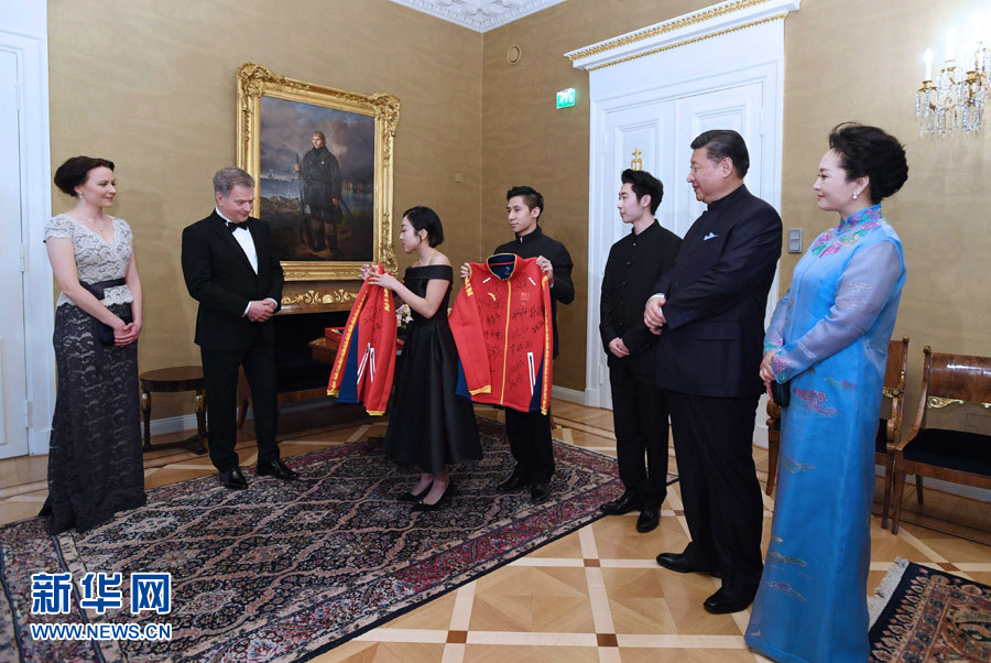 當?shù)貢r間4月5日晚，國家主席習近平和芬蘭總統(tǒng)尼尼斯托在赫爾辛基共同會見剛剛參加完2017年世界花樣滑冰錦標賽的中芬兩國冰雪運動員代表。習近平夫人彭麗媛和尼尼斯托夫人豪吉歐參加會見。這是中國運動員向尼尼斯托和夫人豪吉歐贈送運動衣。新華社記者 饒愛民 攝